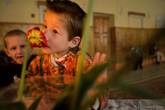 Ein geistig behindertes MÃ¤dchen in einem Waisenhaus in WeiÃŸrussland riecht entrÃ¼ckt an einer Tulpe